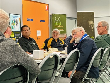 7 men from the AMSA event chatting around a table