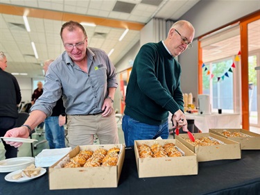 2 men picking food from a table at the AMSA event