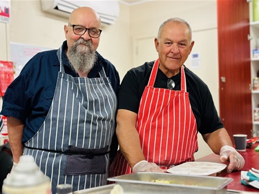 2 men in aprons smiling at the camera at the AMSA event